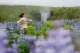 Eri contenta viendo Skógafoss llena de lupines en verano