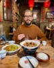 Comiendo en Tianyuankui Guesthouse mientras soy observado por los comensales de atrás